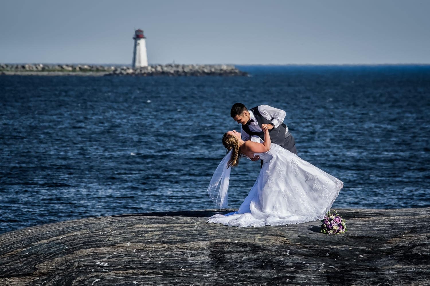 Wedding photography of bride and groom at Point Pleasant Park with lighthouse in the background.