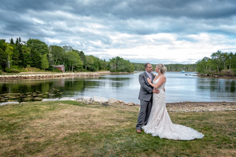 The bride and groom pose for wedding photos by the ocean in Halifax, NS.