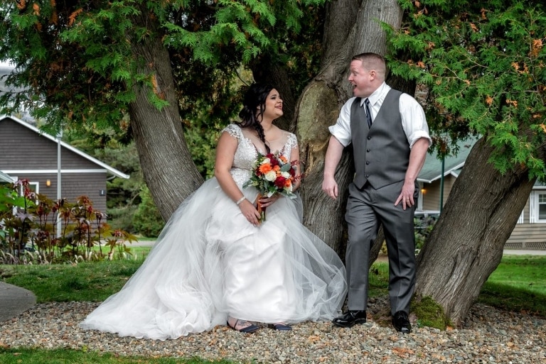 The bride and groom wedding photos taken amongst a huge tree at Digby Pines.