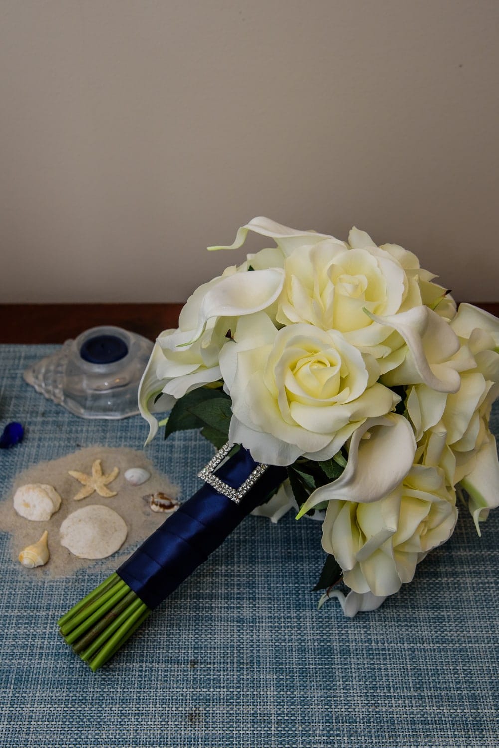 An ivory rose bridal wedding bouquet with navy accents.