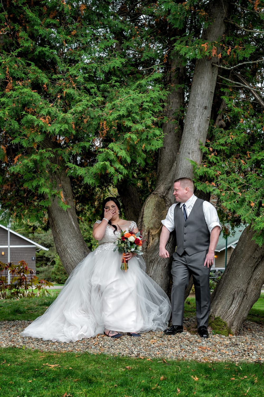 the bride laughing at the groom during wedding photos in a tree at Digby Pines.