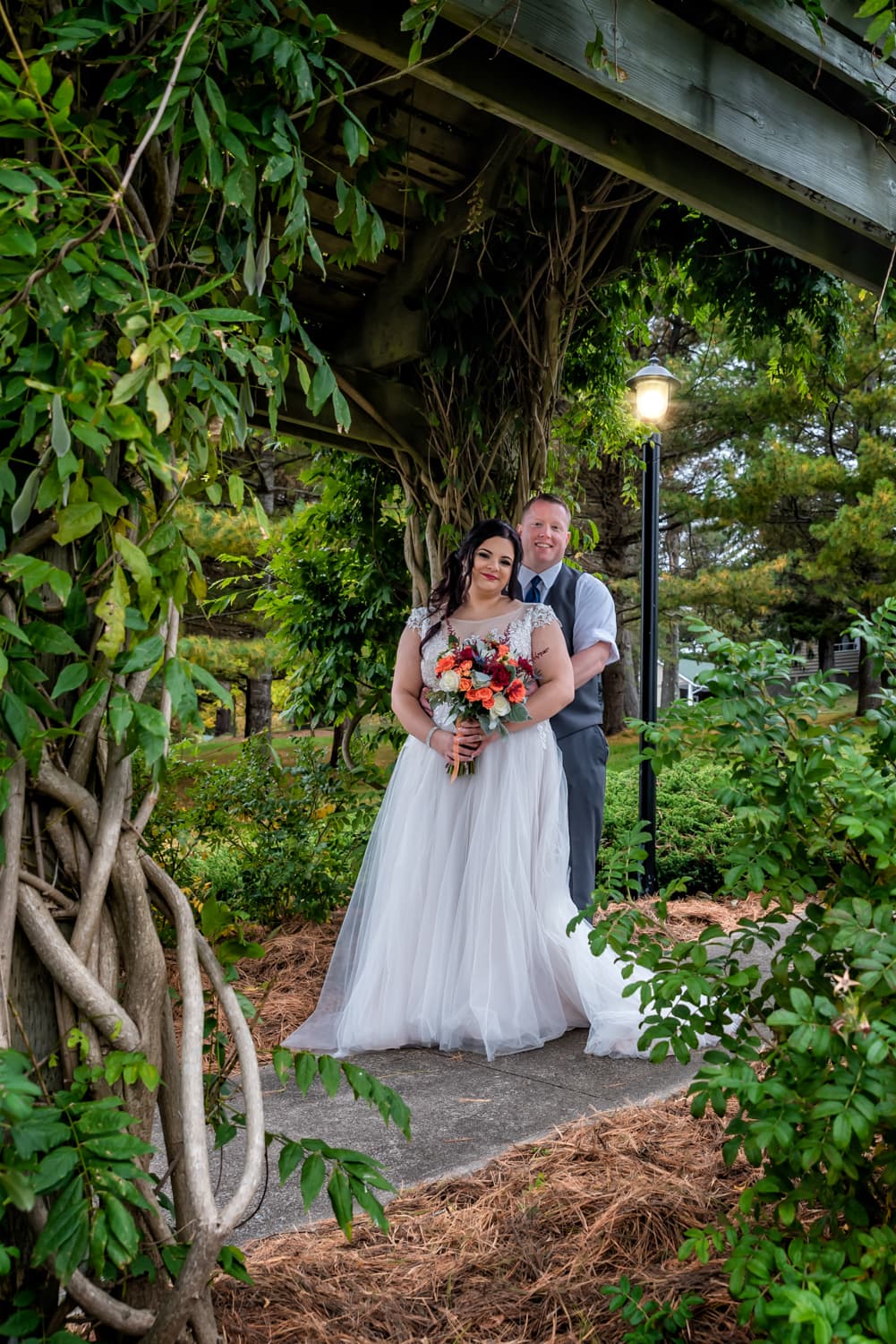 A bride and groom standing under an archway of veins at Digby Pines.