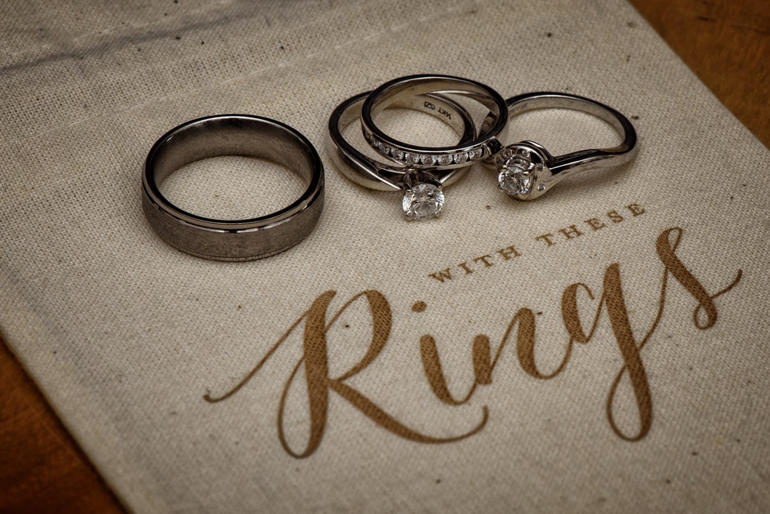 The bride and groom wedding bands on a cute with this ring we thee wed ivory burlap bag.