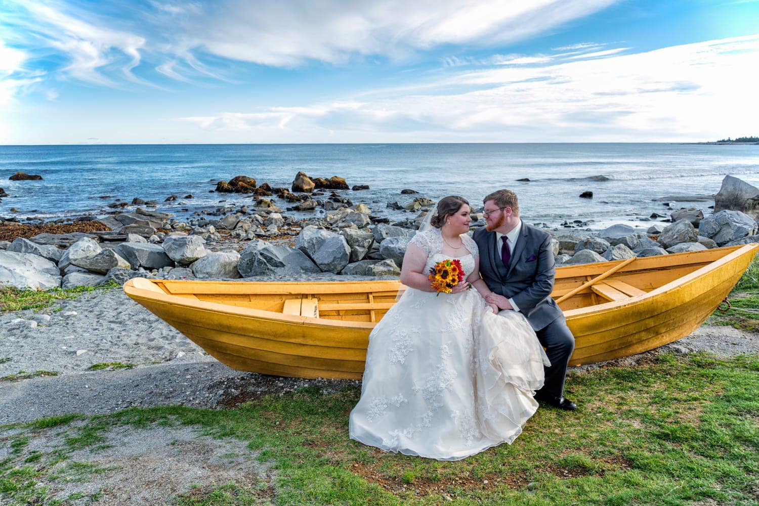 Wedding photos of the bride and groom in a yellow boat at white point beach resort.