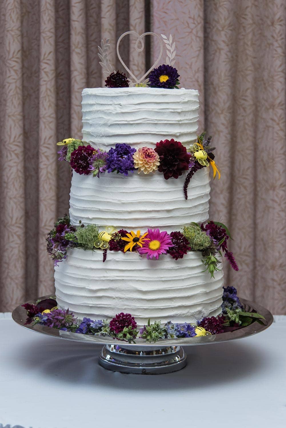 A three tier flower decorated wedding cake at a Best Western Chocolate Lake wedding in Halifax.