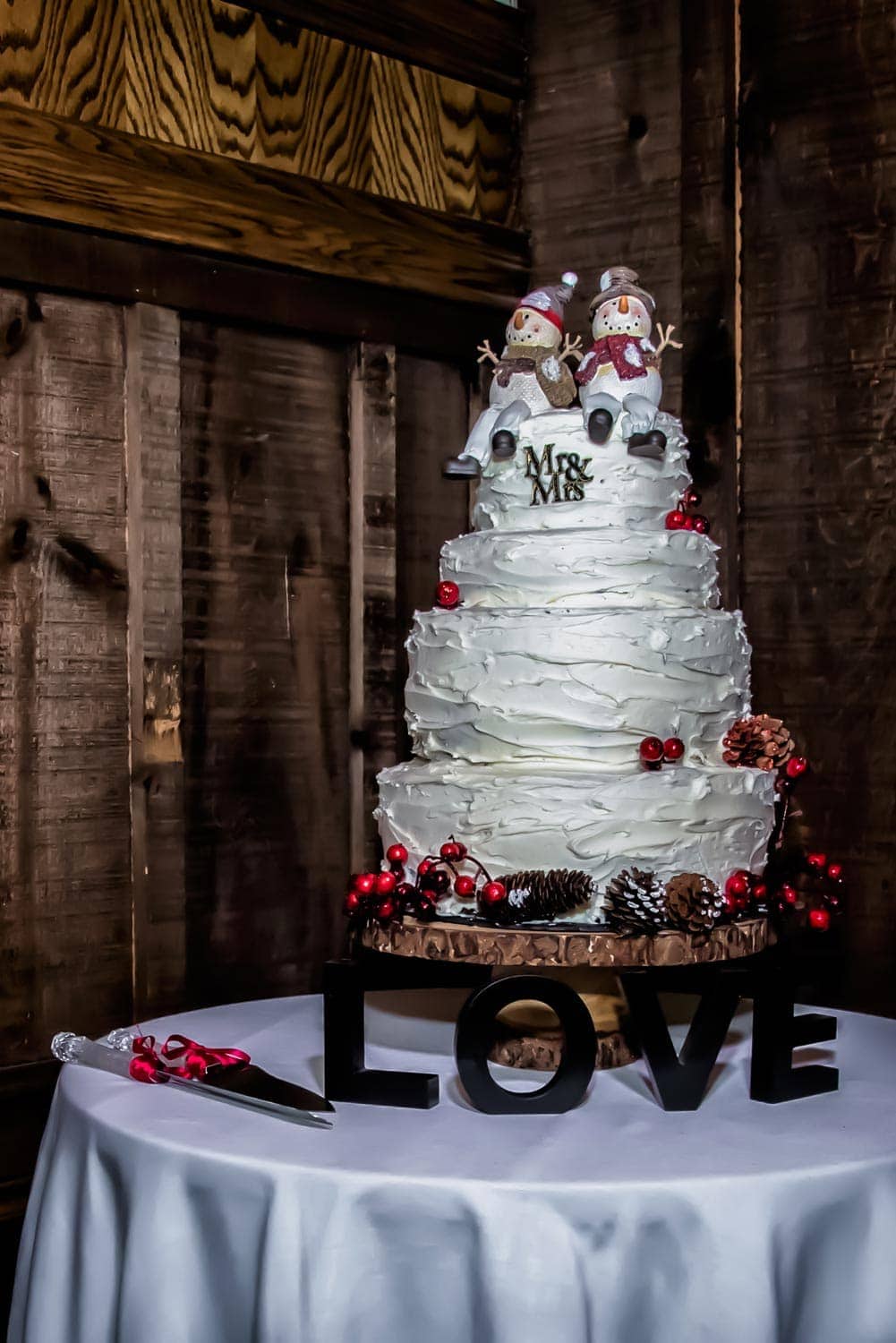 An awesome winter themed wedding cake with snowman wedding cake toppers at a Lower Deck Tap Room wedding.