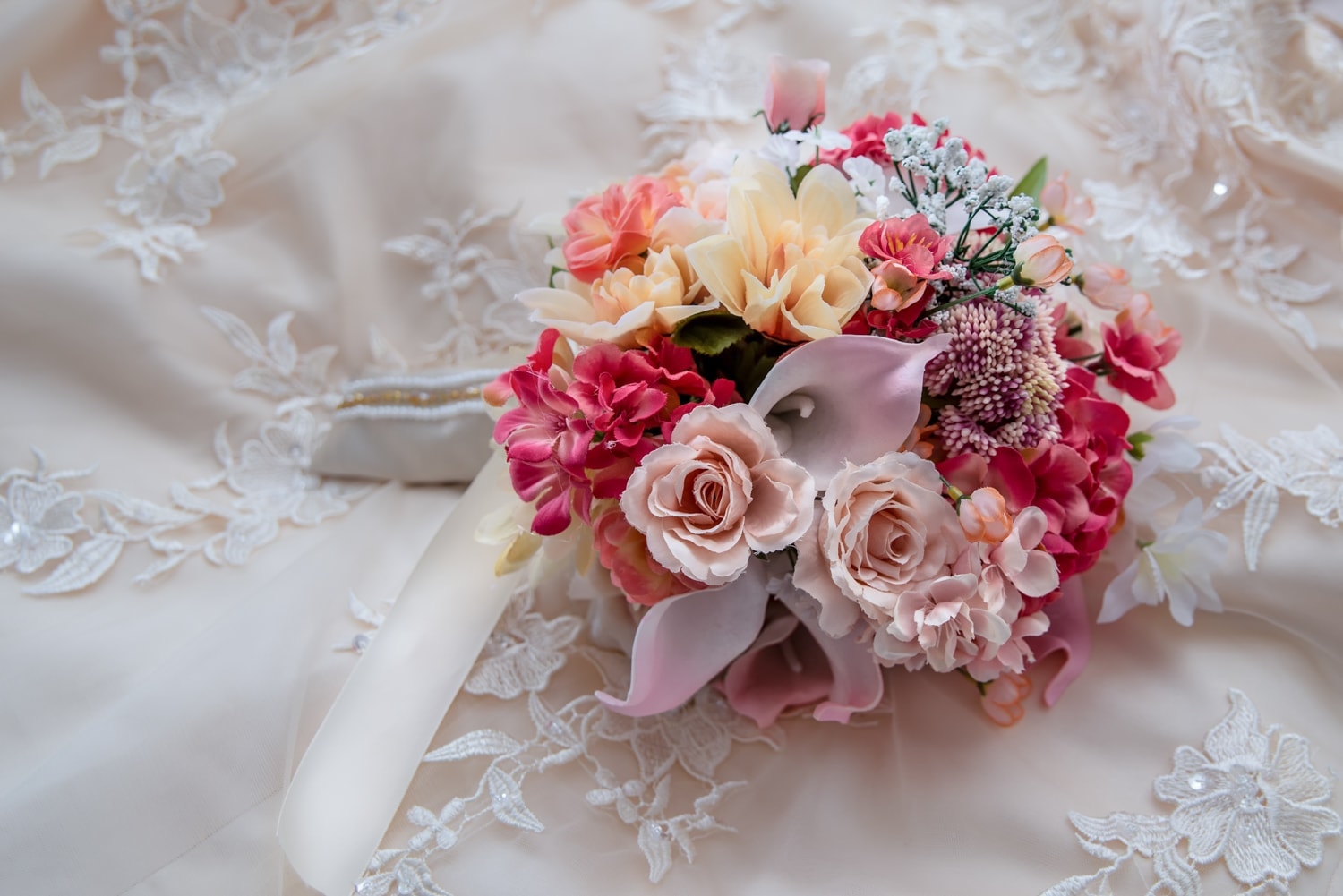 A beautiful pink, ivory and peach silk fake floral wedding bridal bouquet.