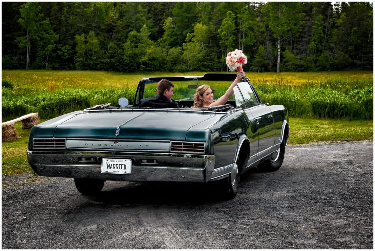 The bride and groom drive away from their wedding ceremony in an antique car headed for their reception at the Brooklyn Civic Center in Newport, NS.