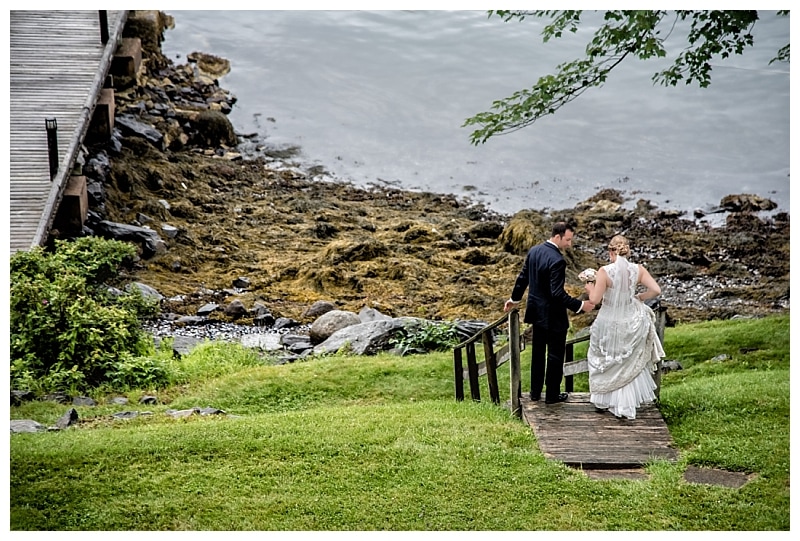 The bride and groom walk towards a wharf at Saraguay House for wedding photos.