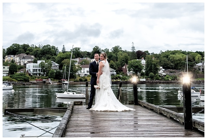 The bride and groom pose for wedding photos on a wharf during a Saraguay House Wedding in Halifax, NS.