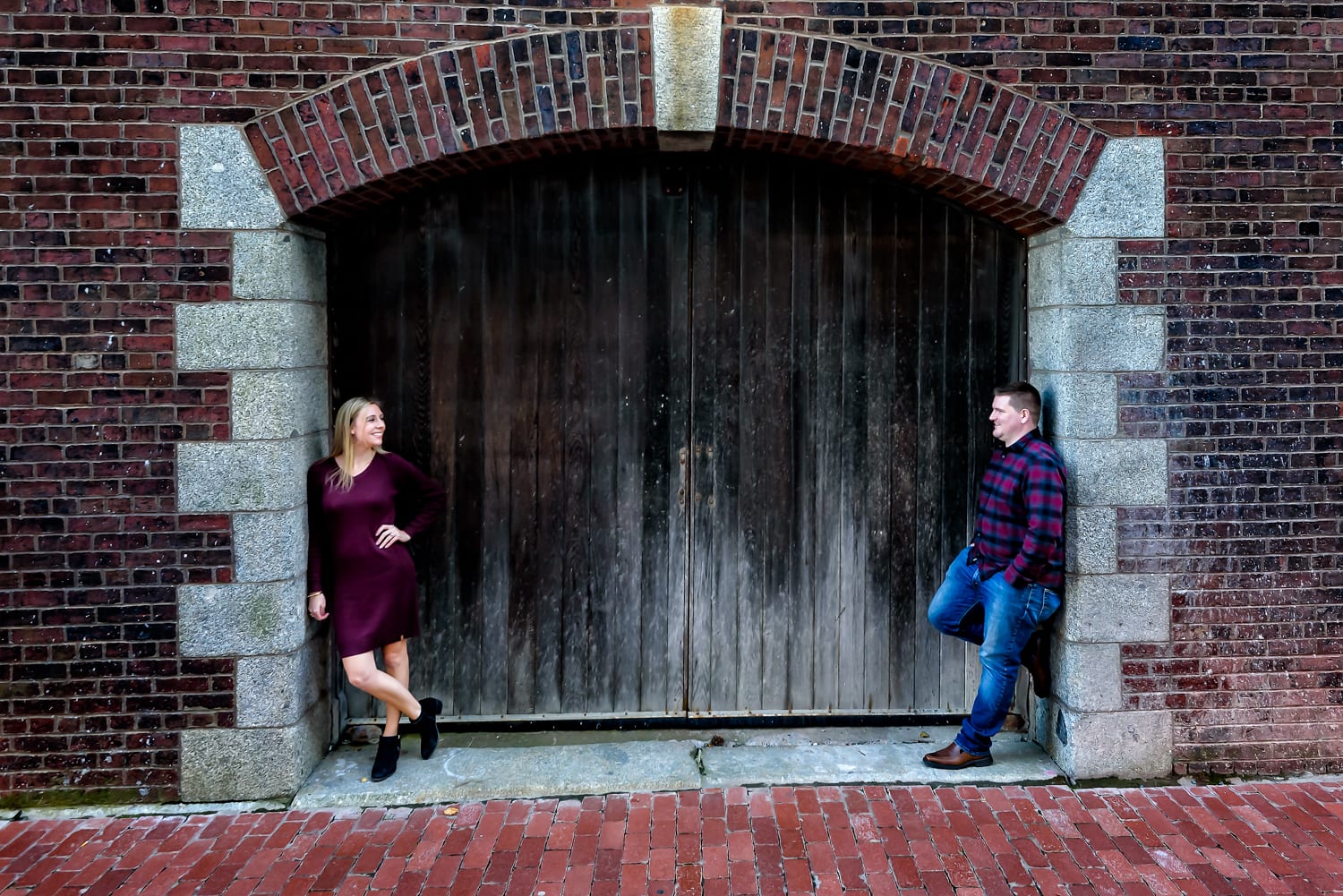 Cute couple in love pose for their urban style engagement photos on the Halifax waterfront.