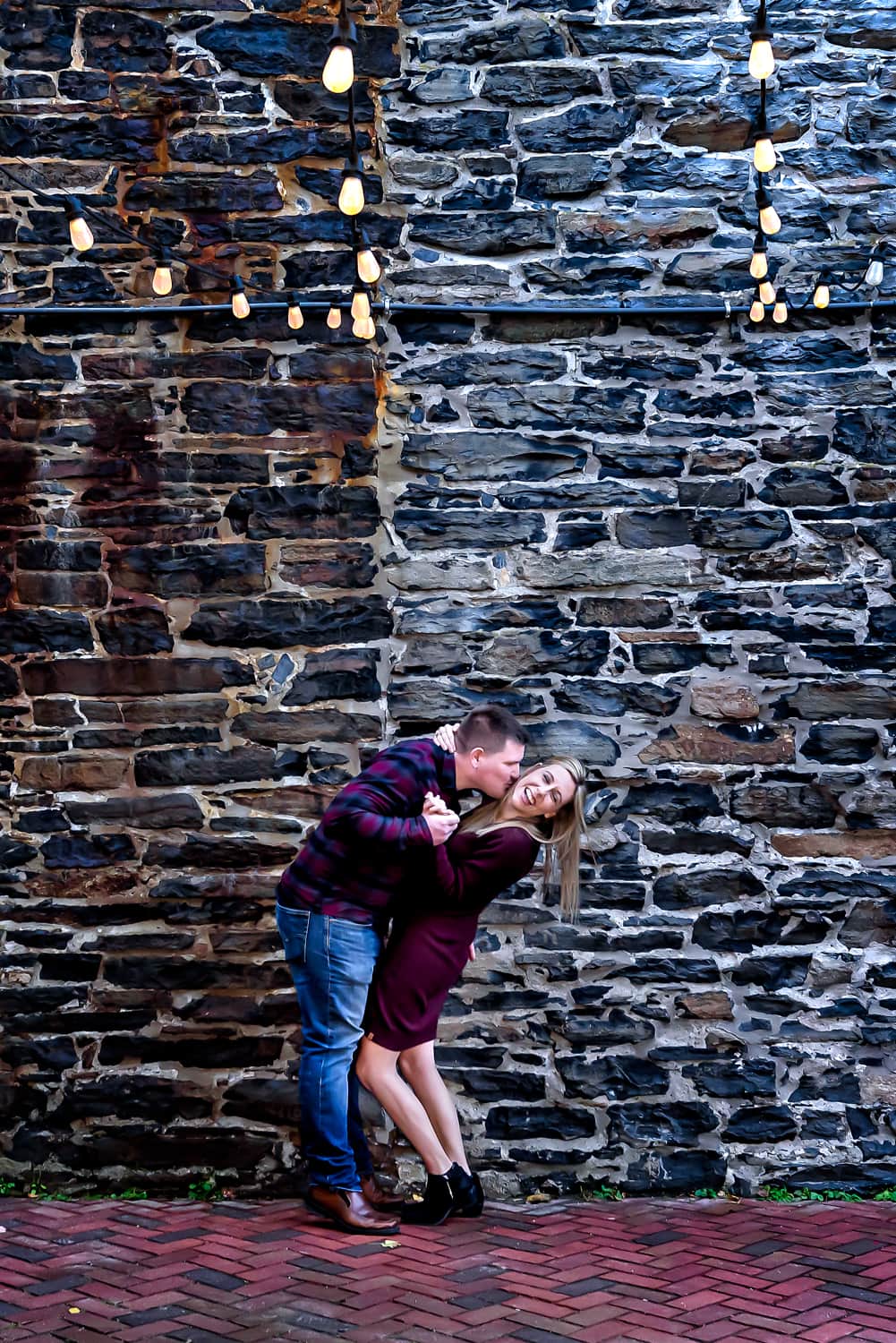 A cute couple plays during their urban style engagement photos on the Halifax waterfront.