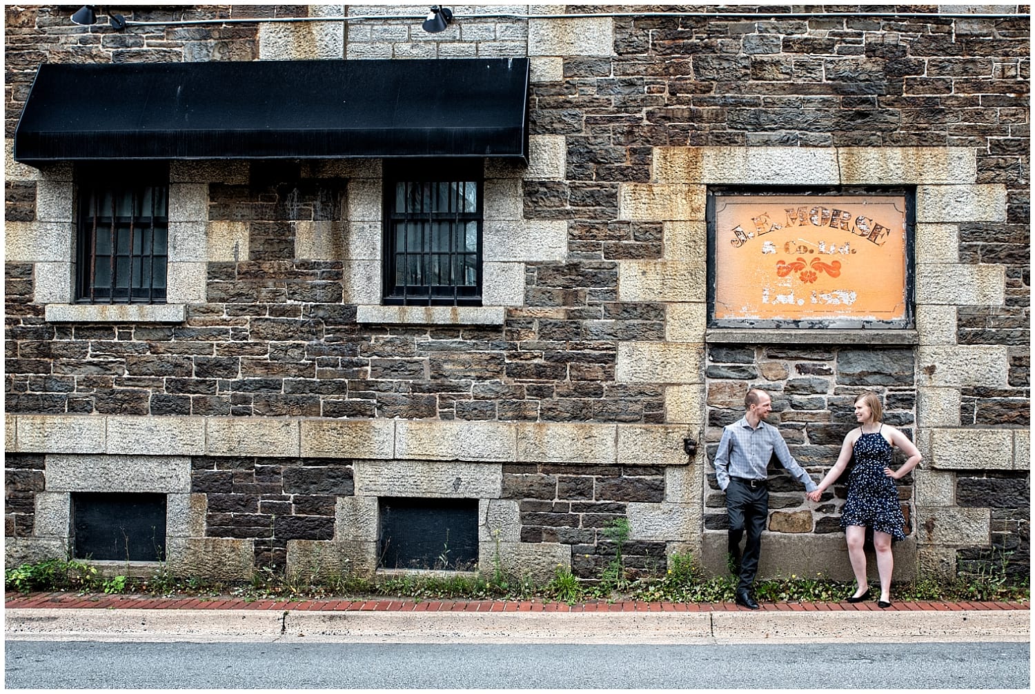A newly engaged couple holds hands during their engagement photos at the Historic Properties in Halifax NS.
