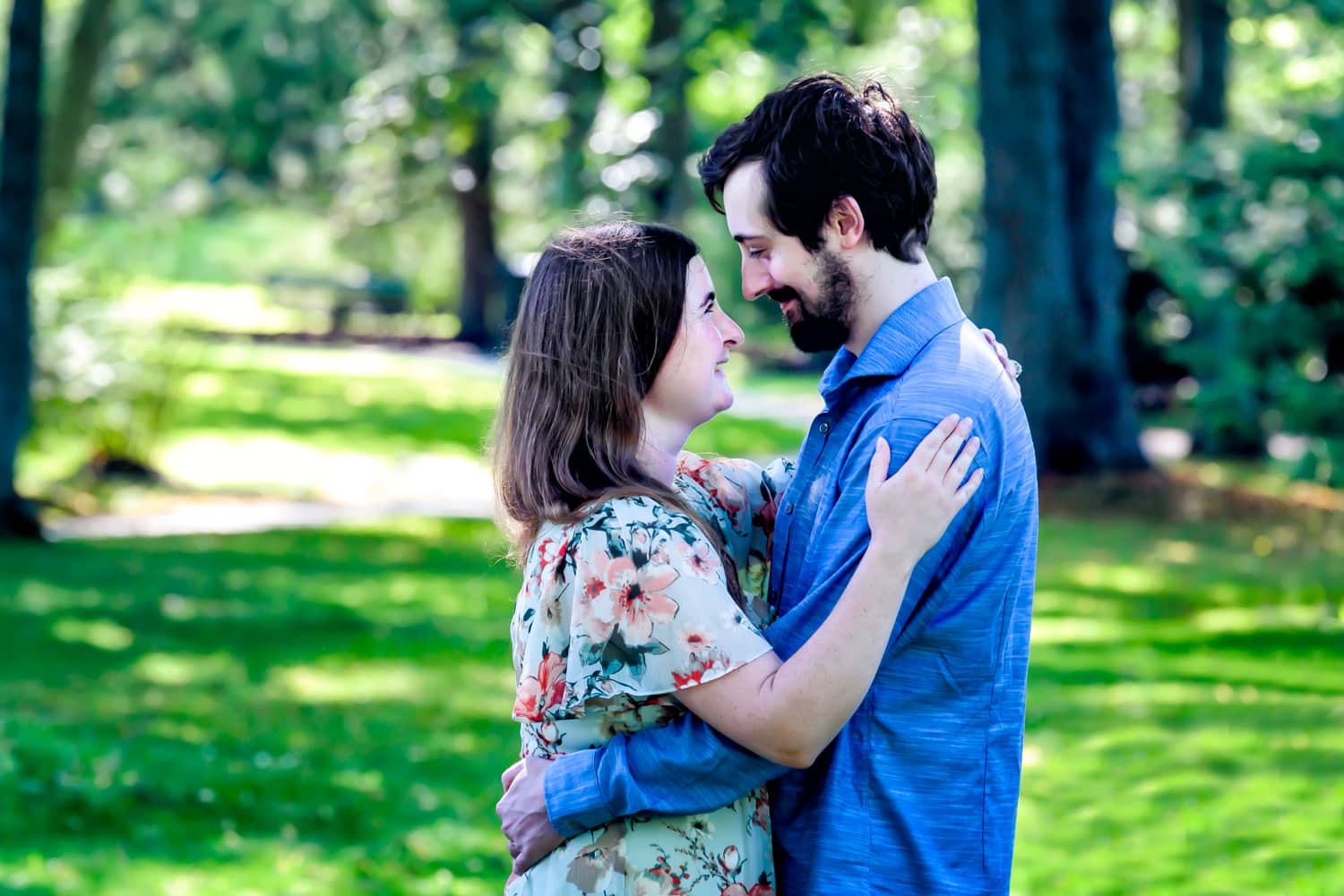 A newly engaged couple stop to embrace in the Public Gardens during their engagement photos in Halifax, NS.