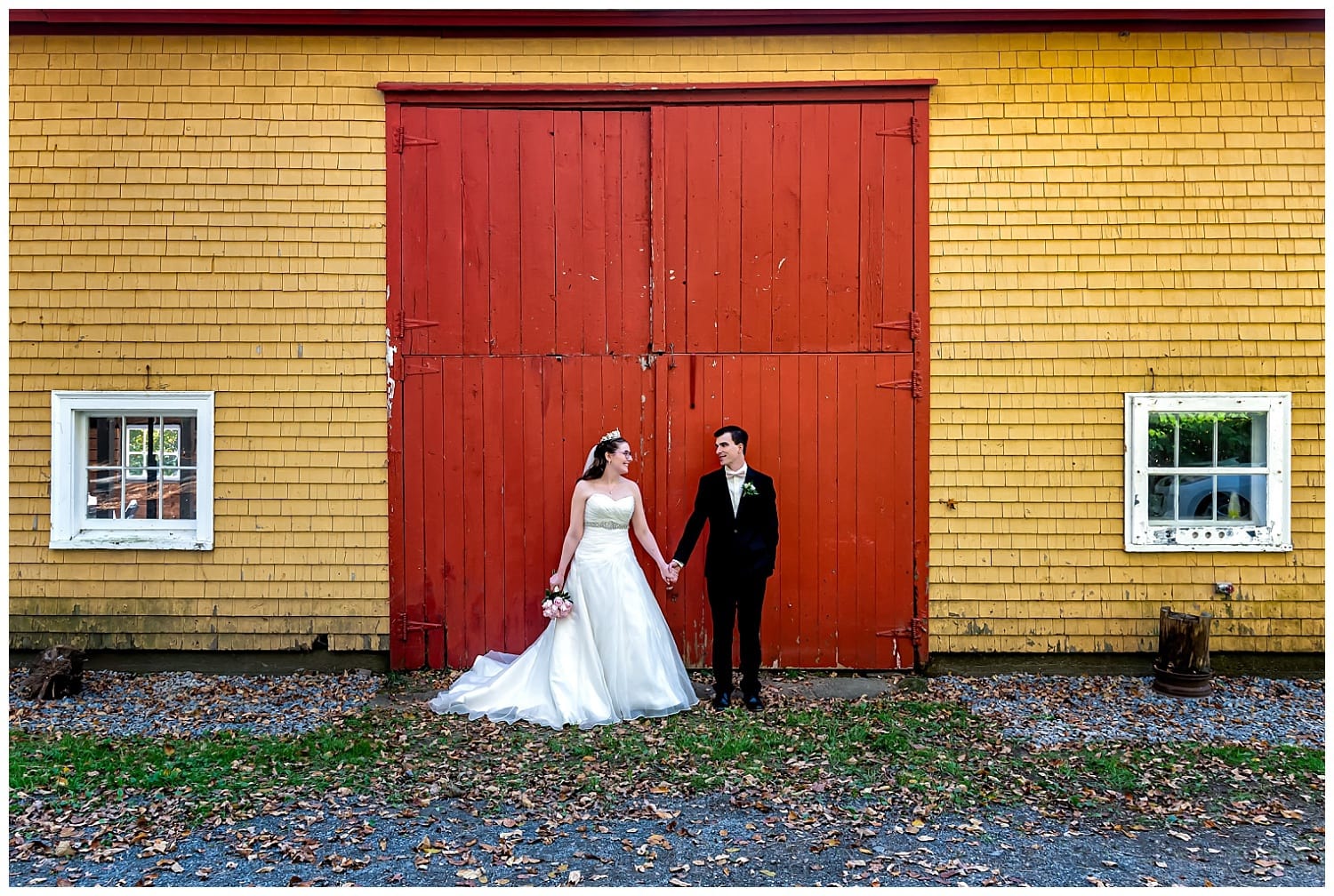 The bride and groom pose for their rustic style wedding photos at the barn on Kinley Farm in Lunenburg NS.