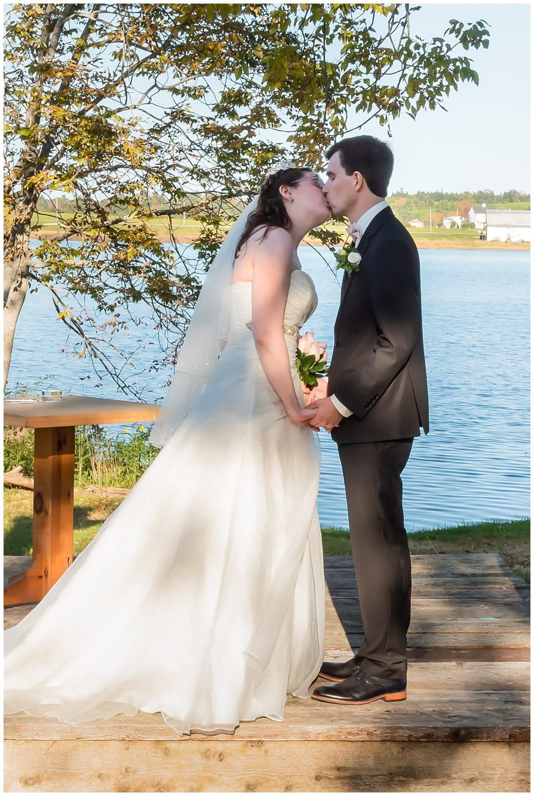 The bride and groom have their first kiss during their wedding ceremony at Kinley Farm in Lunenburg, NS.