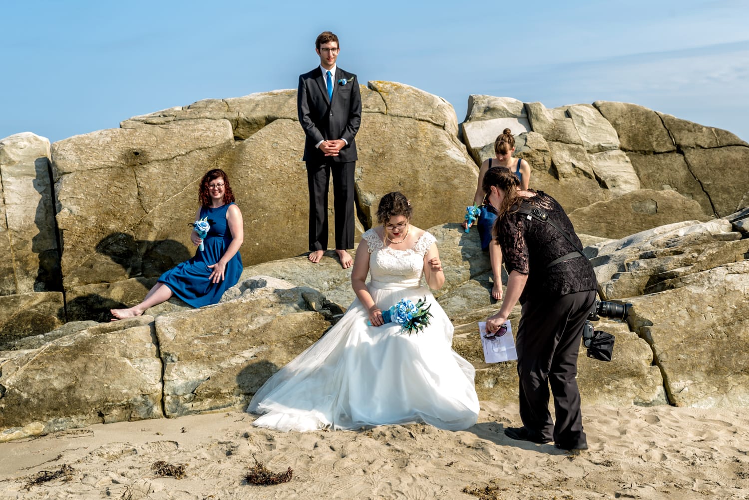 Sandra Adamson's team member helps prepare the bride for wedding party photos in Green Bay, NS.