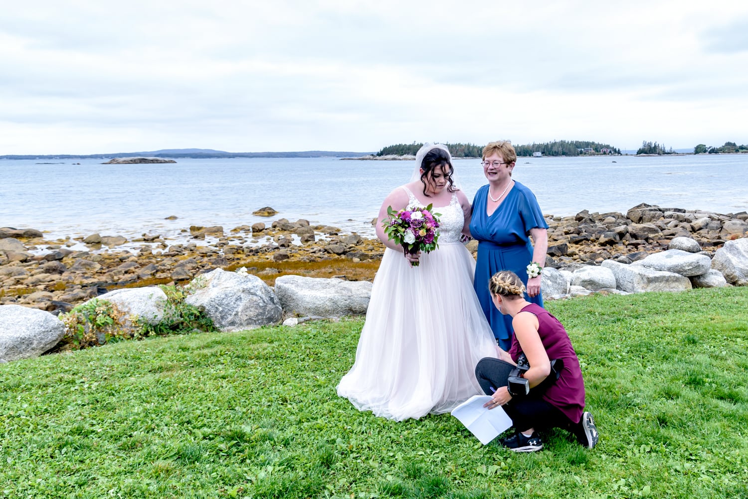 Sandra Adamson's team member fans out a bride's dress during wedding photos at the Oceanstone Resort in NS.