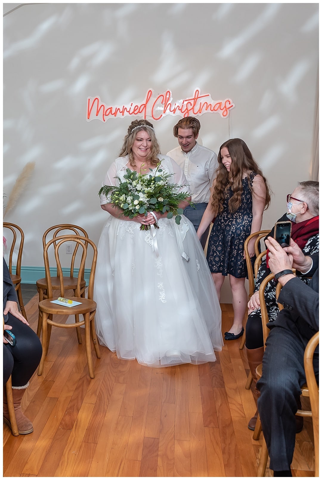 The bride walks up the aisle during her wedding ceremony at the Wolfville Chapel in Nova Scotia.