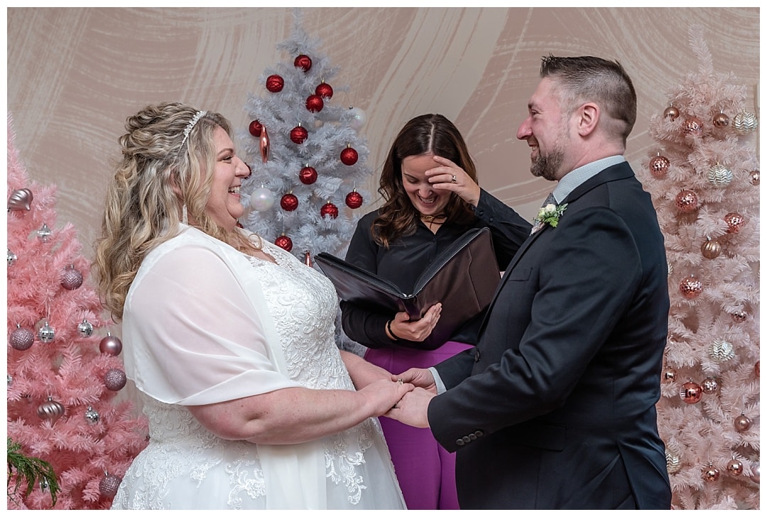 The bride and groom laughing with each other during their wedding ceremony at the Wolfville Chapel in Nova Scotia.