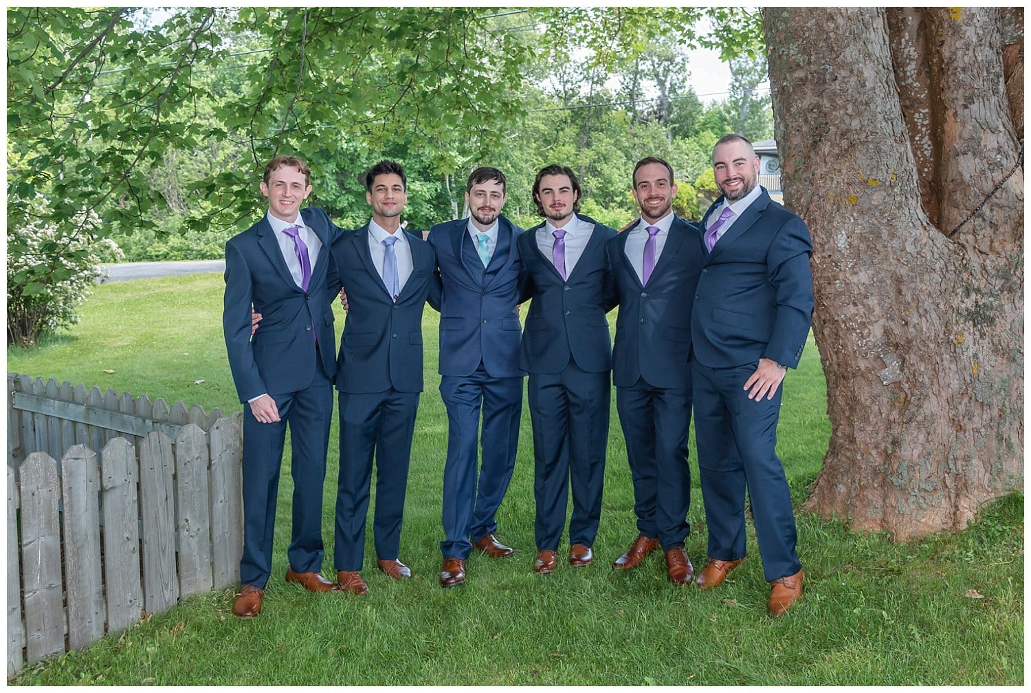 The groom poses for wedding photos with his groomsmen.