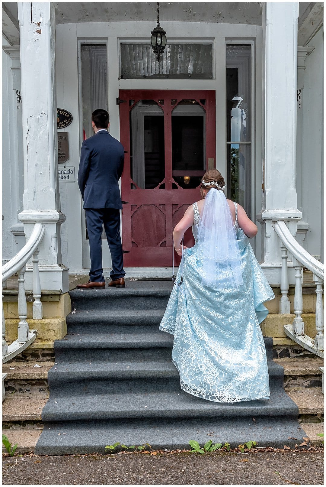 The bride climbs the stairs to tap her soon to be husband on the shoulder for their first look at the Hillsdale House in Annapolis Royal NS.