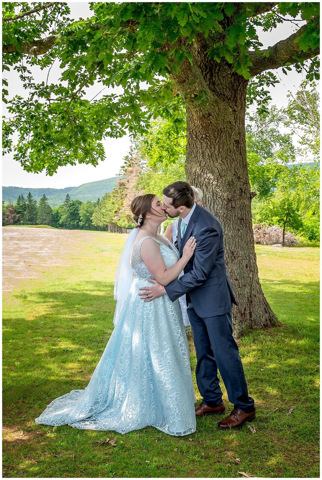 The first kiss during an golf course outdoor wedding ceremony at the Founders House in Annapolis Royal, NS.
