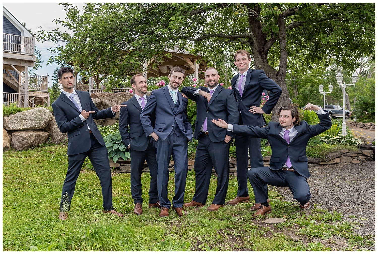 The groom and groomsmen pose for fun wedding photos at the Founders House in Annapolis Royal NS.