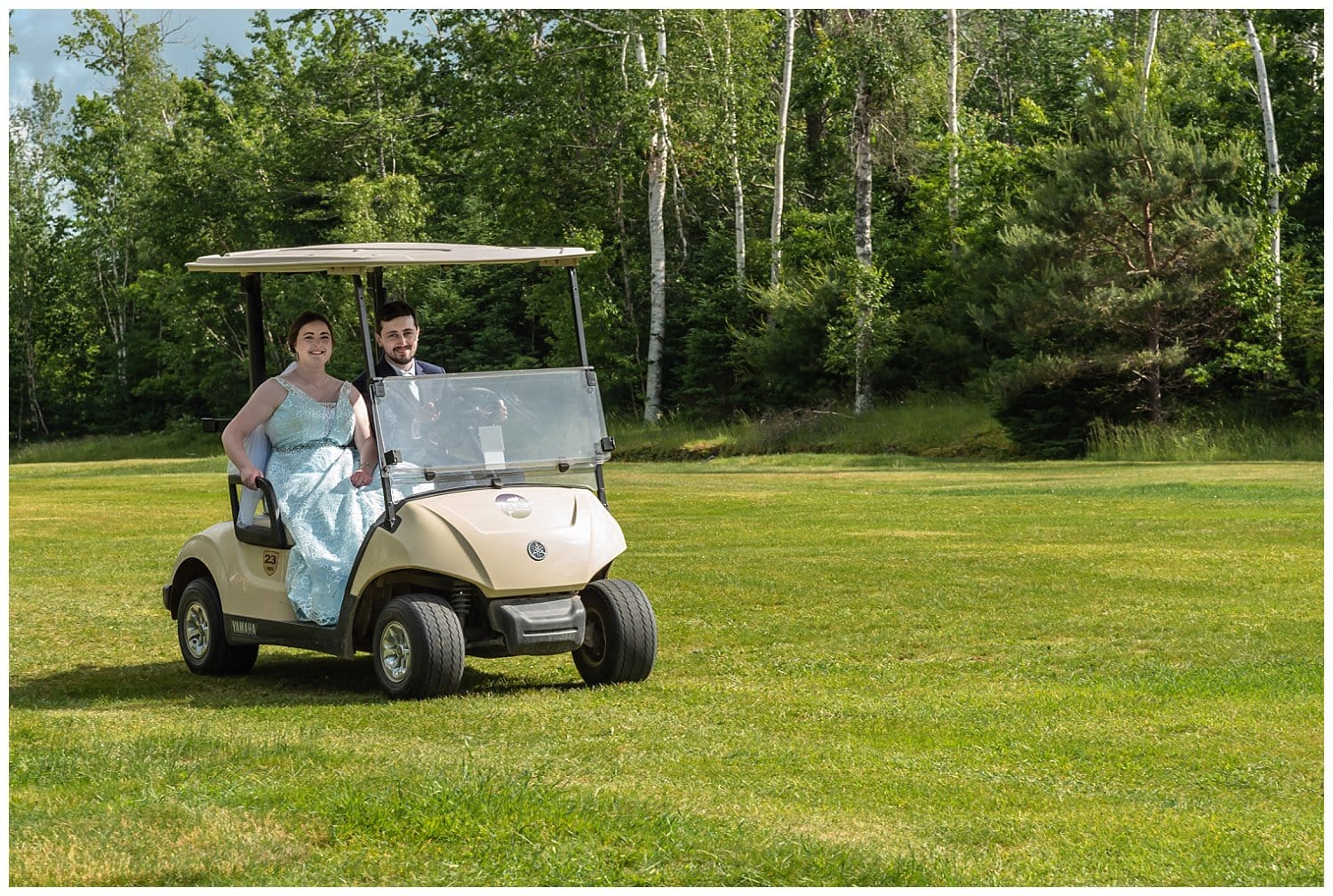 The bride and groom drive themselves back to the wedding reception in a golf cart from their outdoor wedding ceremony.