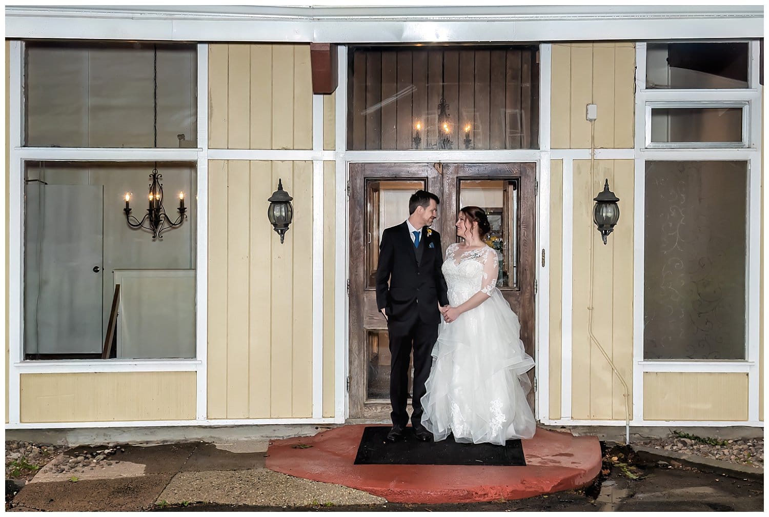 The bride and groom pose in front of the Saraguay House for wedding photos.