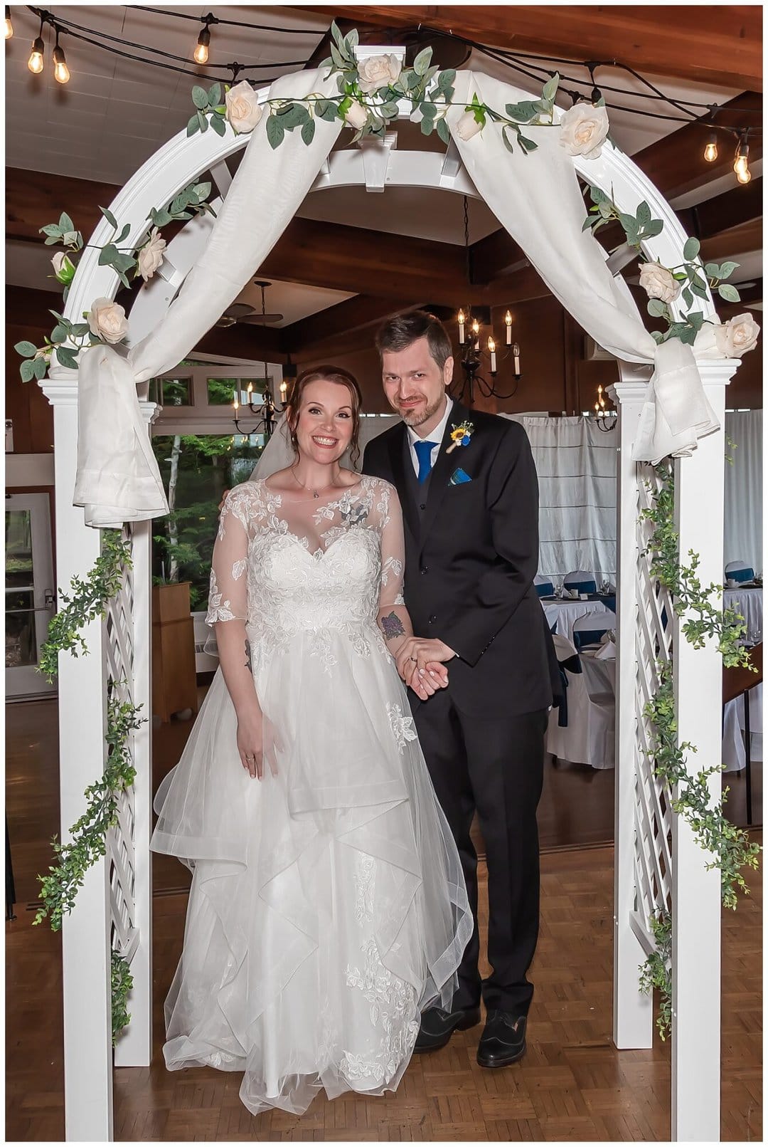 The bride and groom stand under the wedding trellis during their ceremony at Saraguay House in Halifax, NS.
