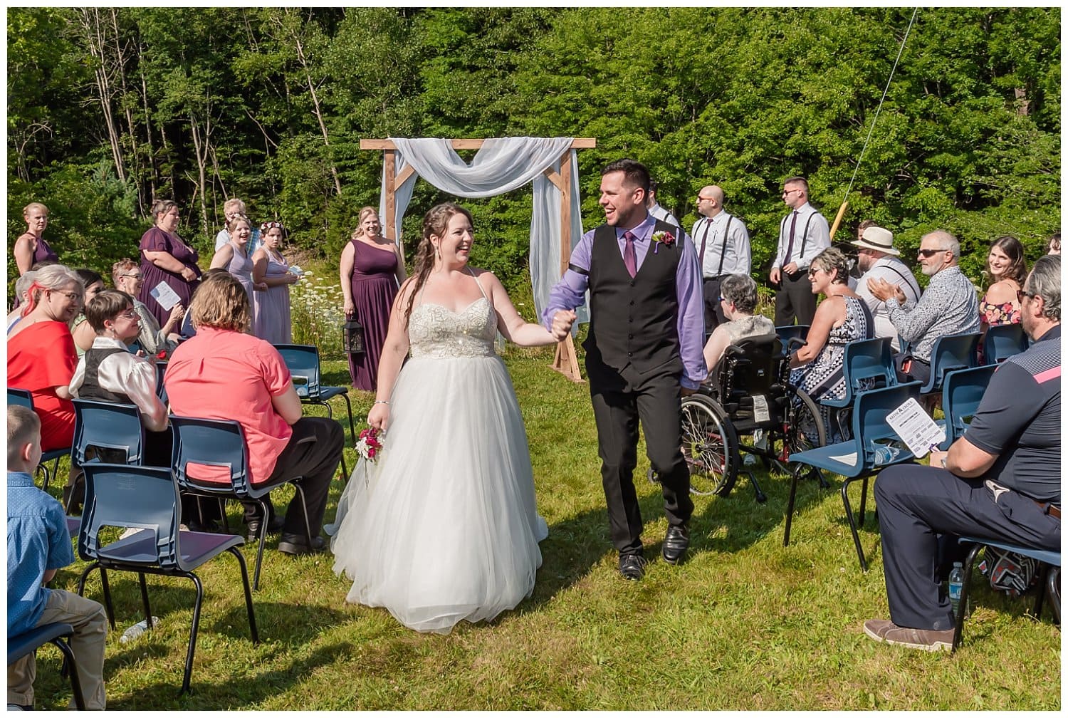 The bride and groom walk back down the aisle after their outdoor wedding ceremony at the Lower Sackville Lions Club.
