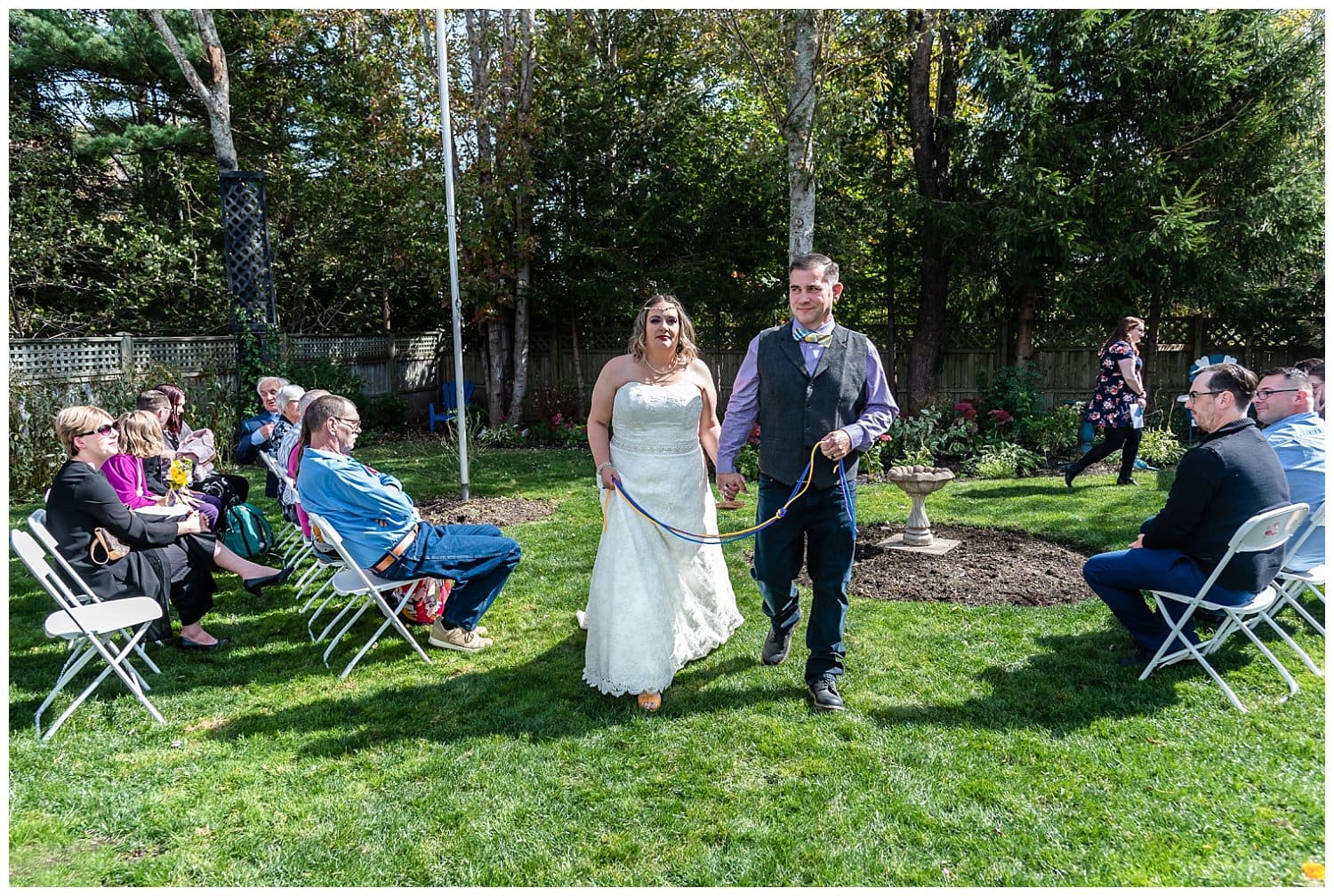 The newly wedded bride and groom walk down the aisle together during their backyard wedding in Dartmouth NS.