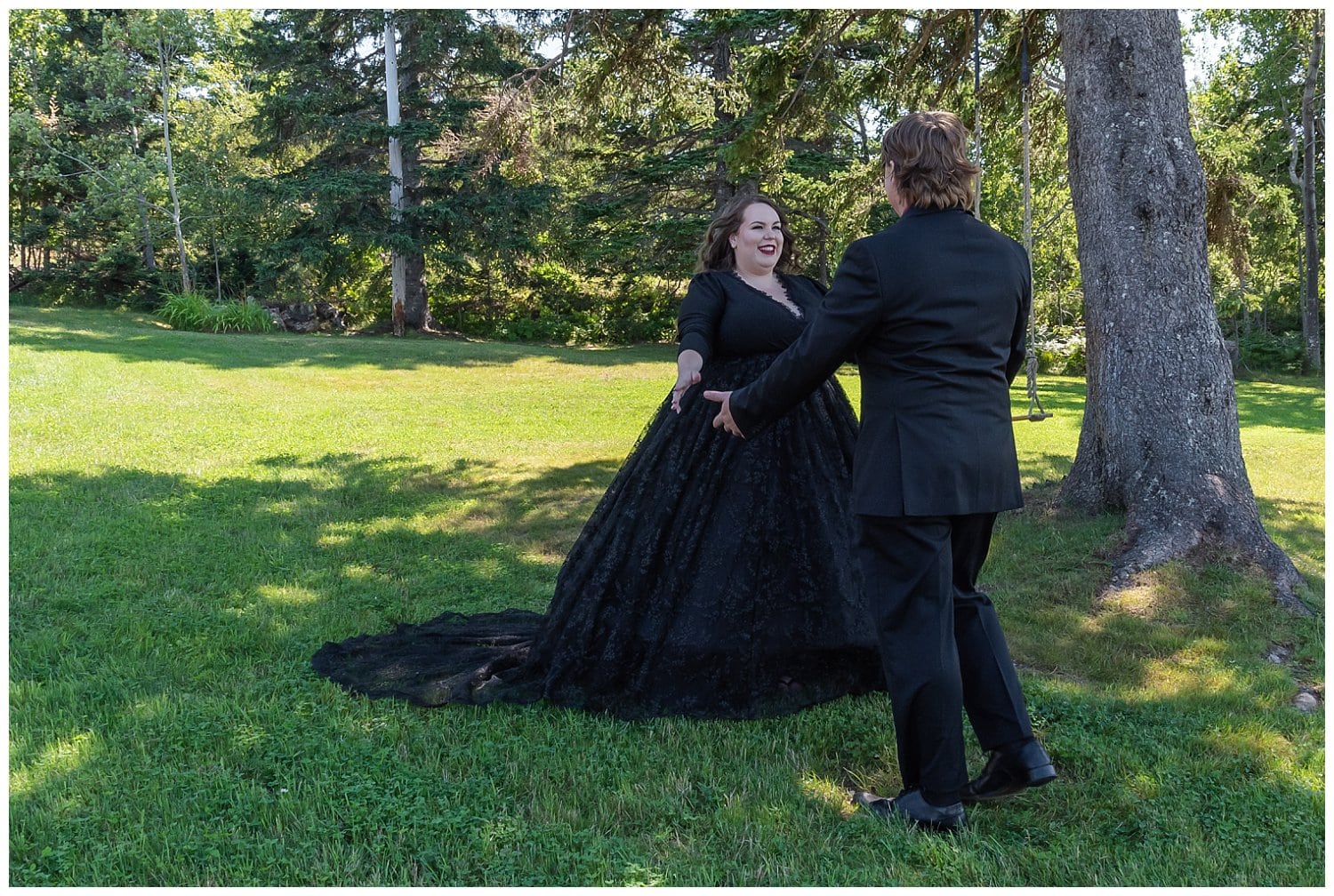 The bride and groom have their first look moment and smile at each other with open arms.