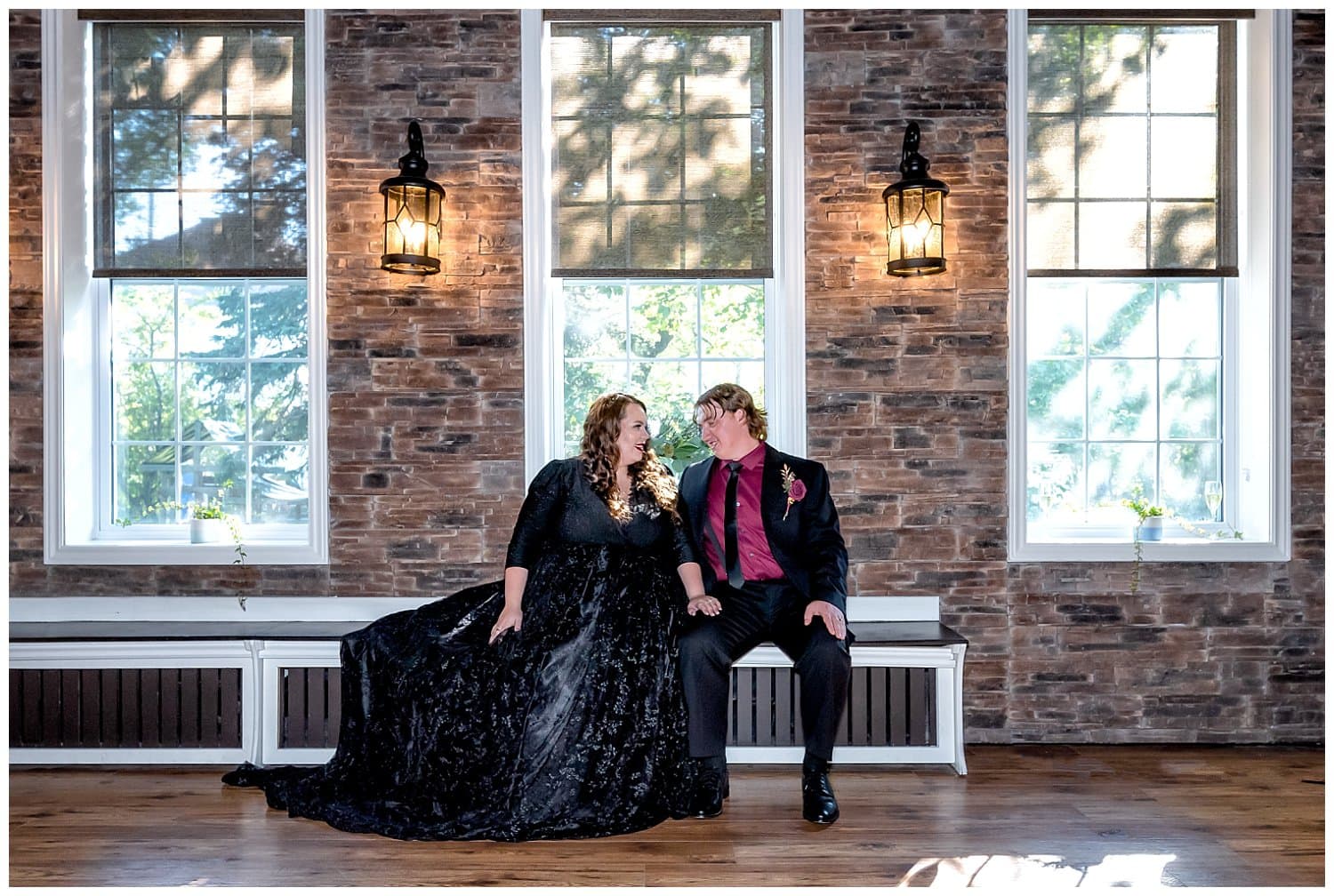 The bride and groom posing for wedding photos upstairs at the Forrester Center against a beautiful brick urban backdrop.