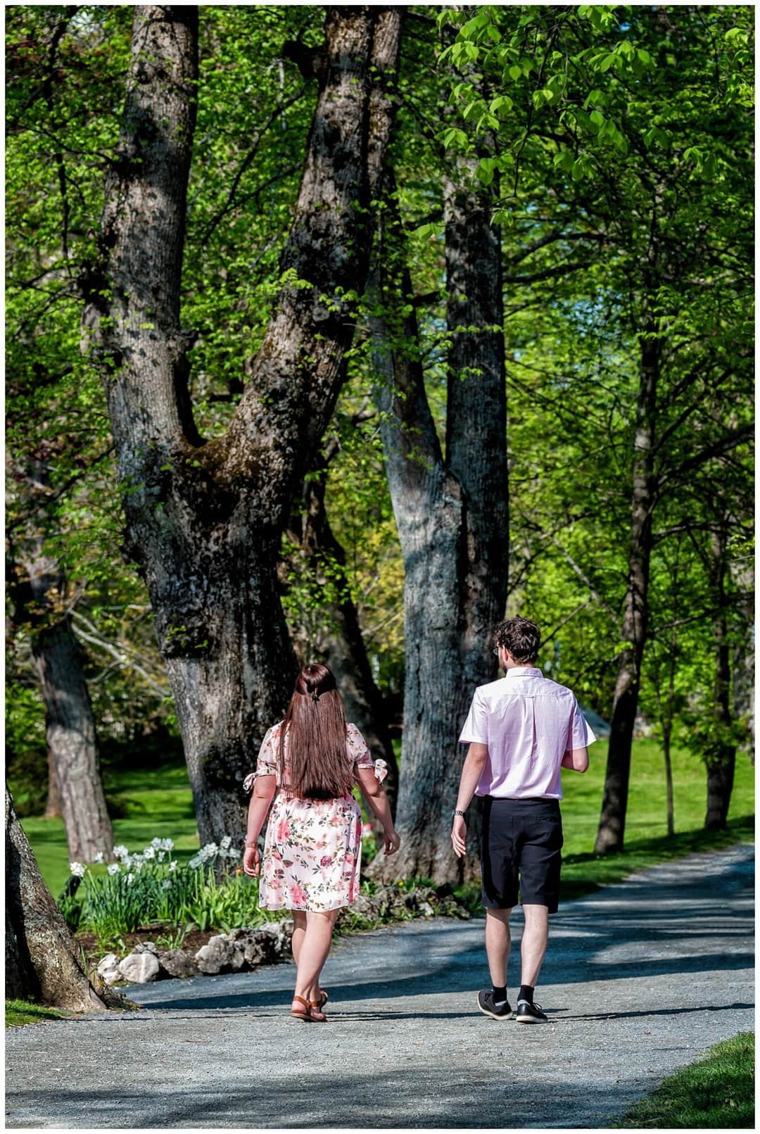 A girlfriend and boyfriend walking along a pathway in the Halifax Public Gardens before he pops the will you marry me questions!