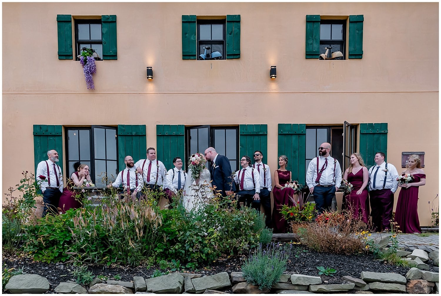 The bride, groom and wedding party pose for wedding photos in front of the Bent Ridge Winery in NS.