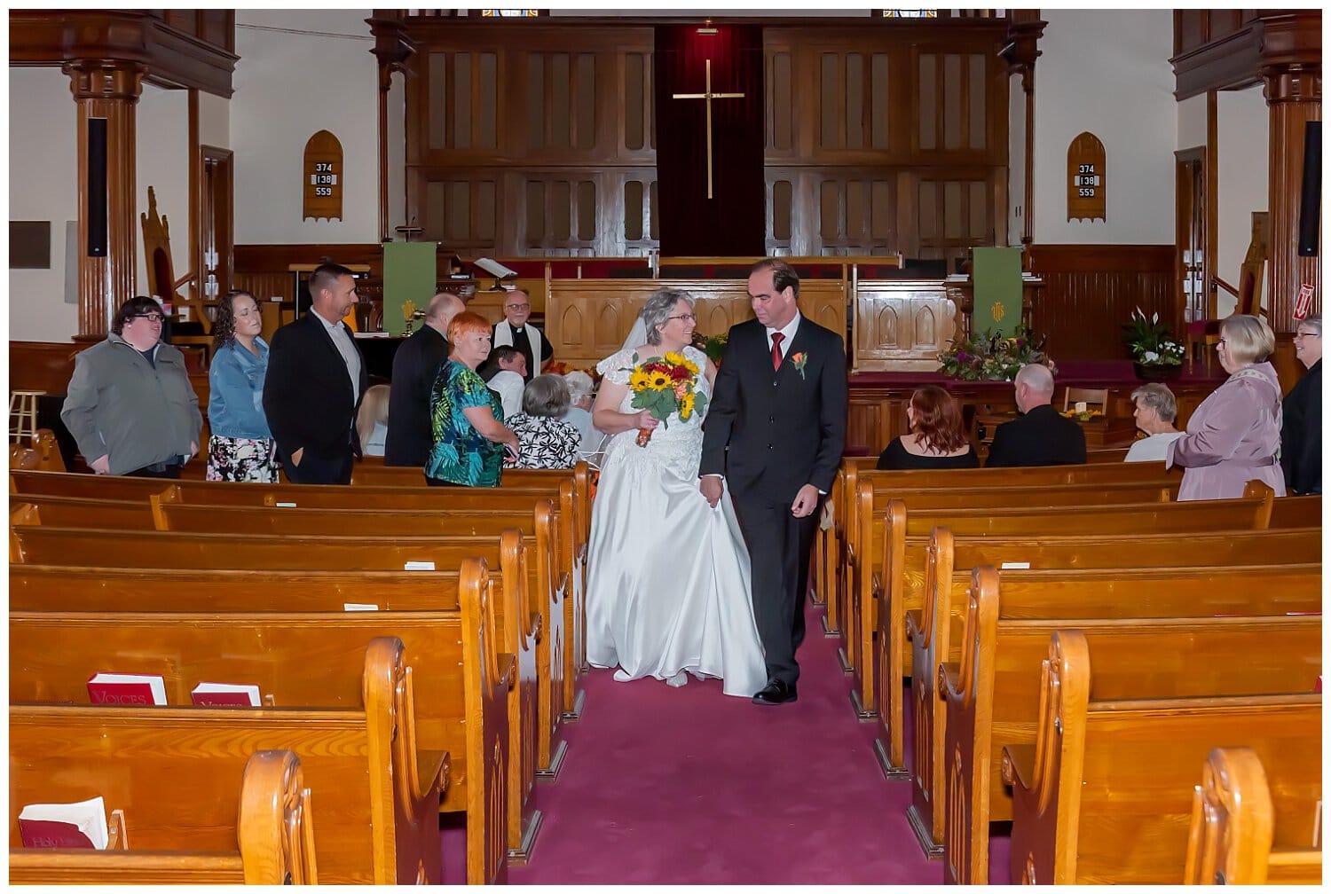 The bride and groom walk back down the aisle after their church wedding in Windsor NS.
