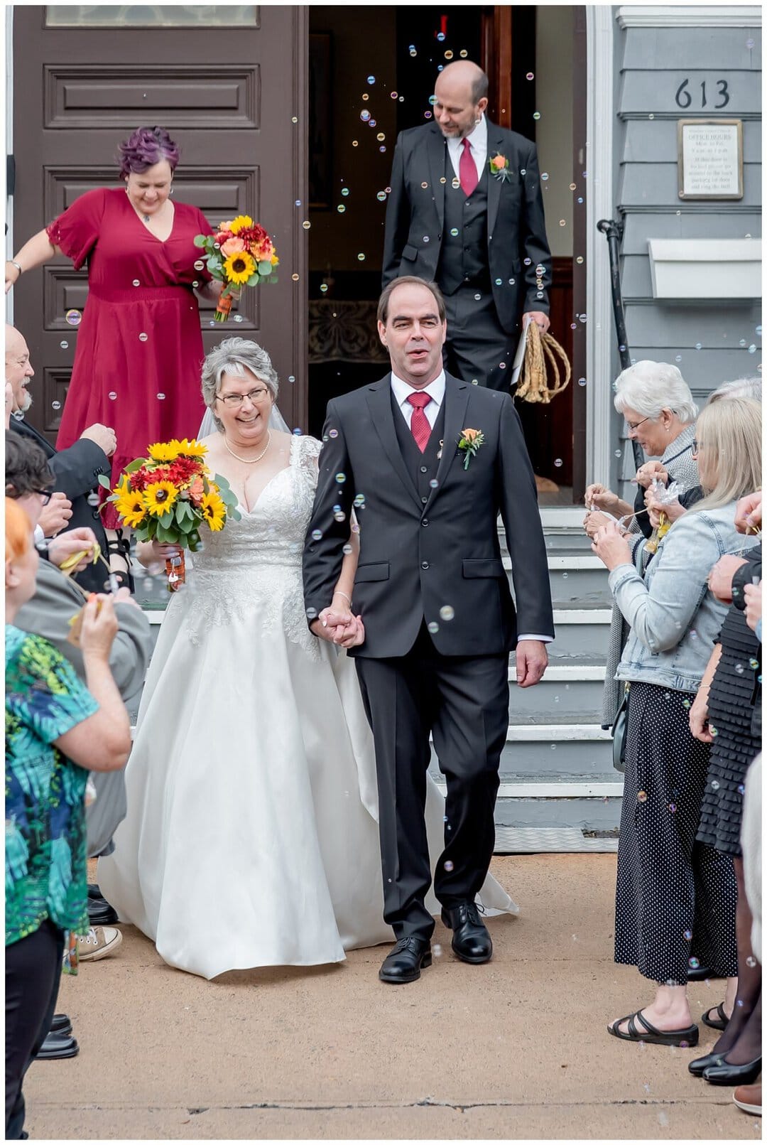The bride and groom walk out of the church to an envelopment of bubbles.