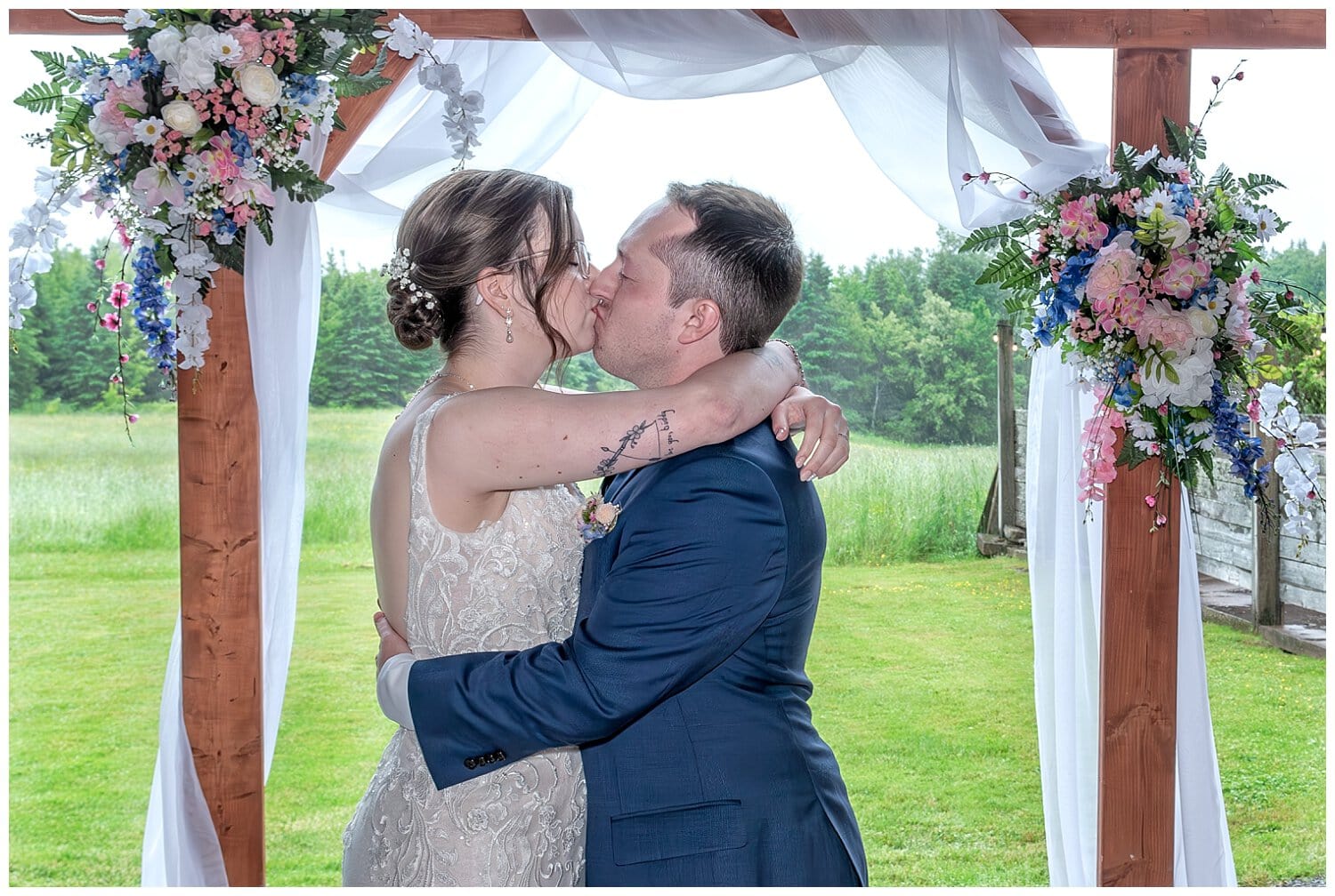 The bride and groom have their first kiss during their wedding ceremony at Parkers Barn in Hopewell NS.
