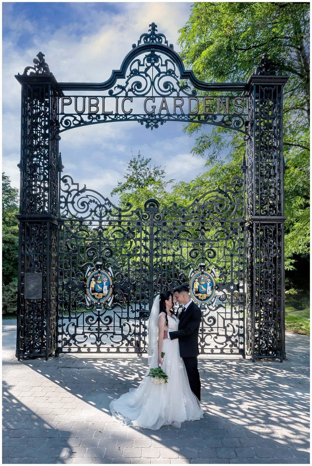 The bride and groom pose for wedding photos in front of the beautiful rod iron gates of the public gardens in Halifax.