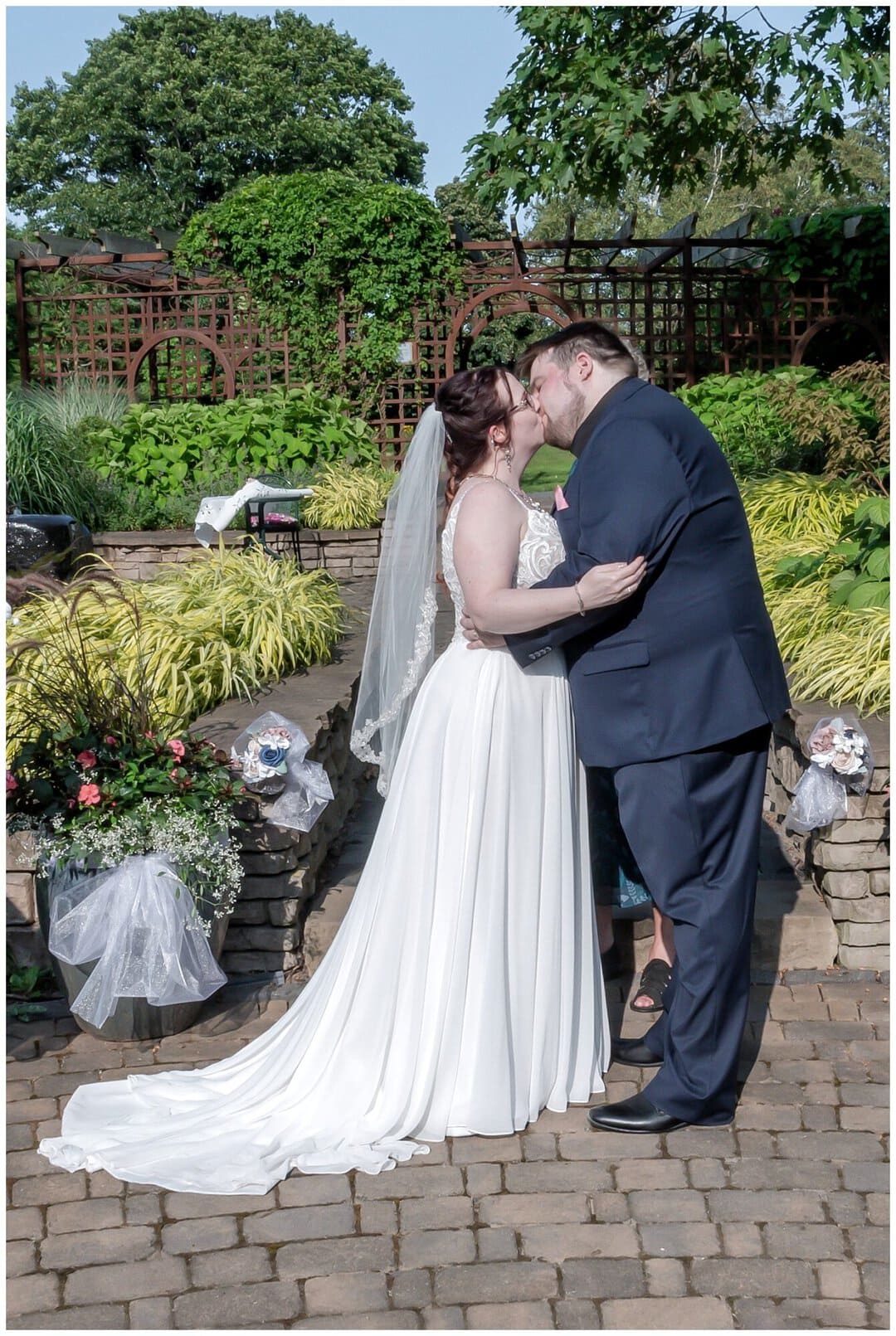 The bride and groom having their first kiss as husband and wife during their wedding ceremony at the Alumni Garden in Truro NS.