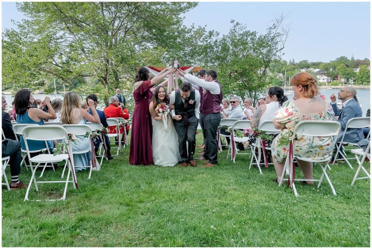 The wedding party create a tunnel for the bride and groom to walk through during their walk back down the aisle at Saraguay House in Halifax NS.