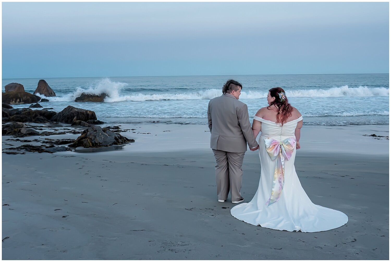 The brides poser on the beach at the end of their wedding day at White Point Beach Resort in NS.