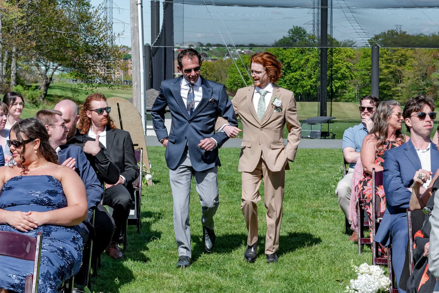 Groom walking down the aisle with his father at Ashburn Golf Club in Halifax during the outdoor wedding ceremony.