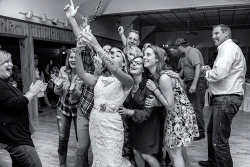 The bride taking a wedding selfie with her wedding guests at her wedding at the Salmon River Firehall in Nova Scotia.