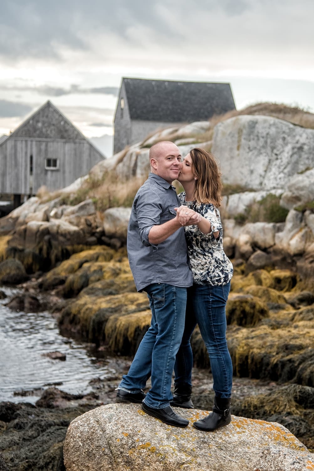 A love couple having their engagement photos done at Peggys Cove in Nova Scotia.