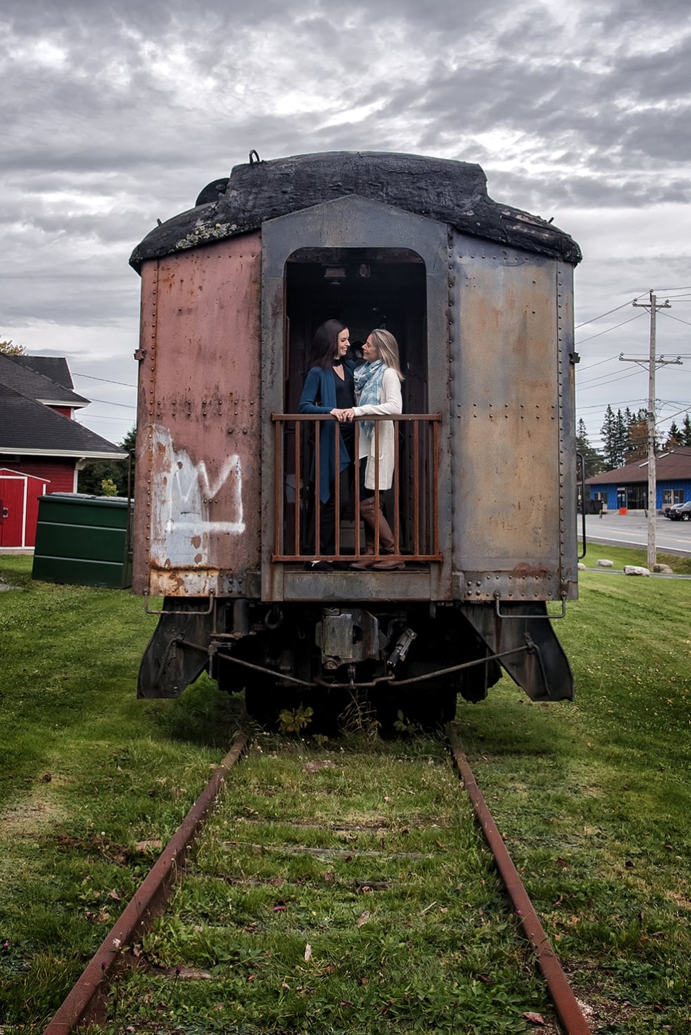 An LGBT lesbian couple on a train during engagement photos at the Musquodoboit Train Museum in Nova Scotia.