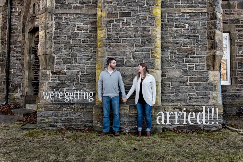 A couple hold hands against the gatehouse in Point Pleasant Park in Halifax, NS.