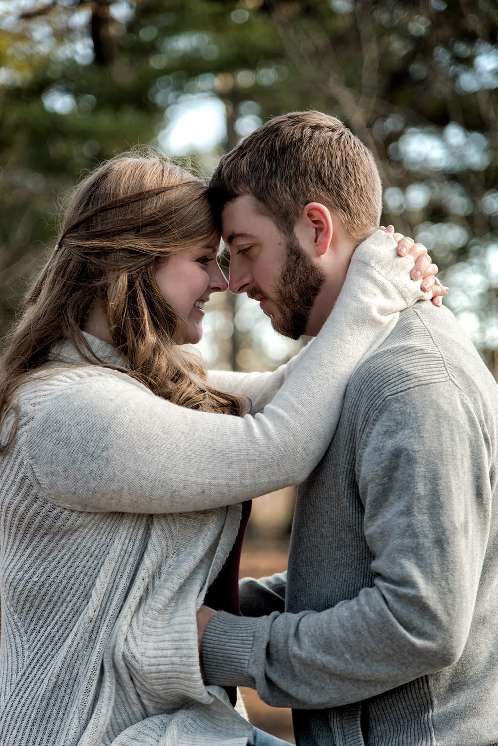 A couple forehead to forehead during their engagement photo session at Point Pleasant Park in Halifax, NS.